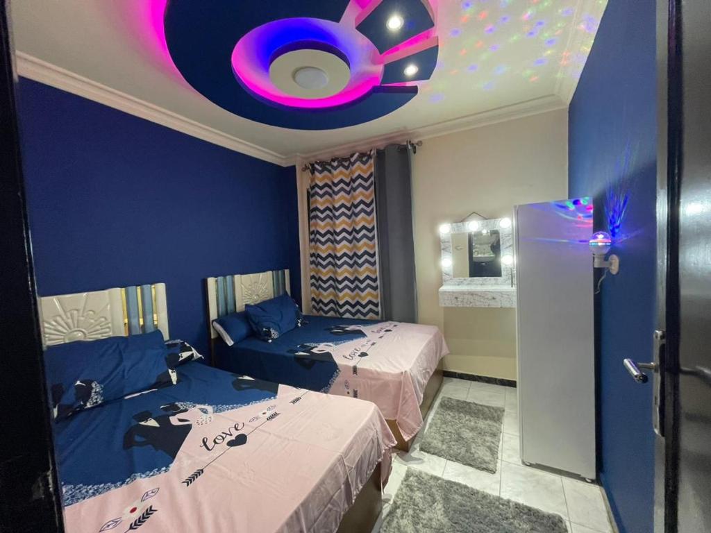 1 dormitorio con 2 camas y techo púrpura en سيدي بشر بحري امام بير مسعود, en Alejandría