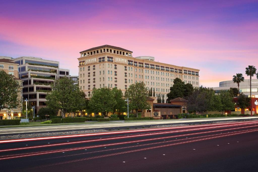 a large white building on a city street at Juniper Hotel Cupertino, Curio Collection by Hilton in Cupertino