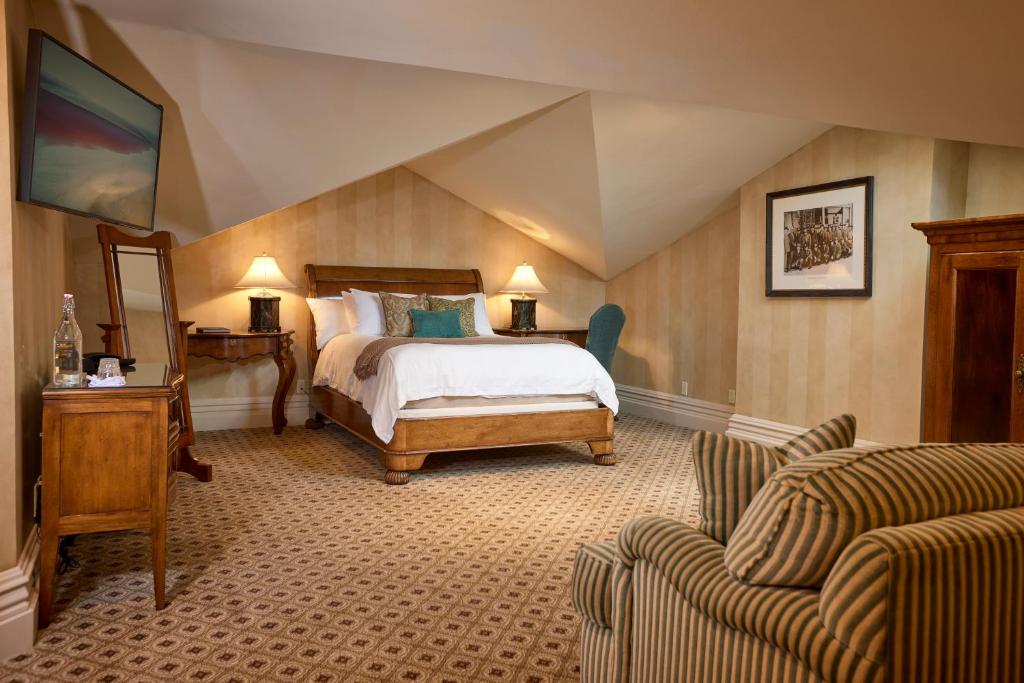 a bedroom with a bed and a couch at Mansion Hill Inn in Madison