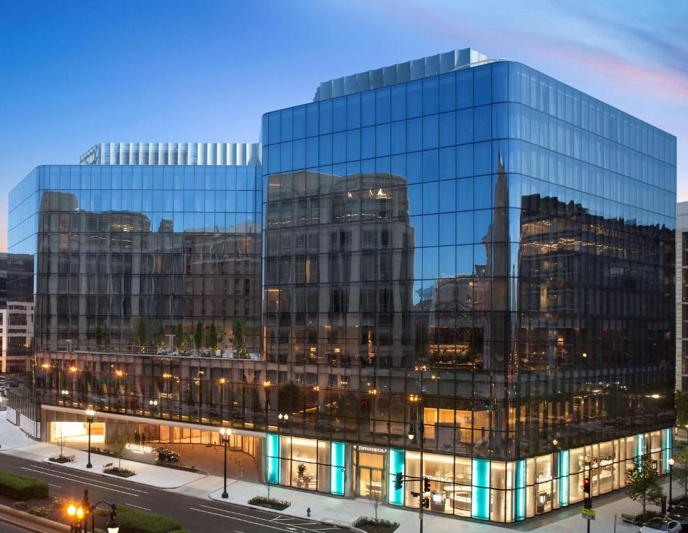 duży szklany budynek biurowy z włączonymi światłami w obiekcie Conrad Washington DC w Waszyngtonie