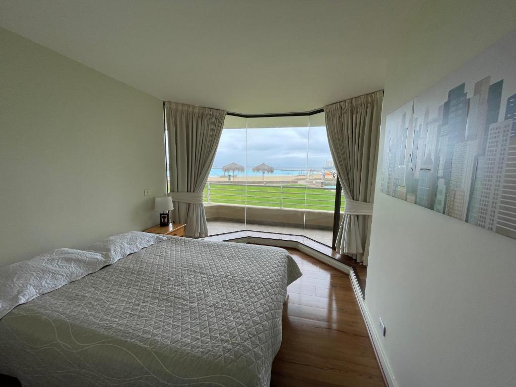 a bedroom with a bed and a large window at San Alfonso del Mar - Algarrobo Valparaiso in Algarrobo