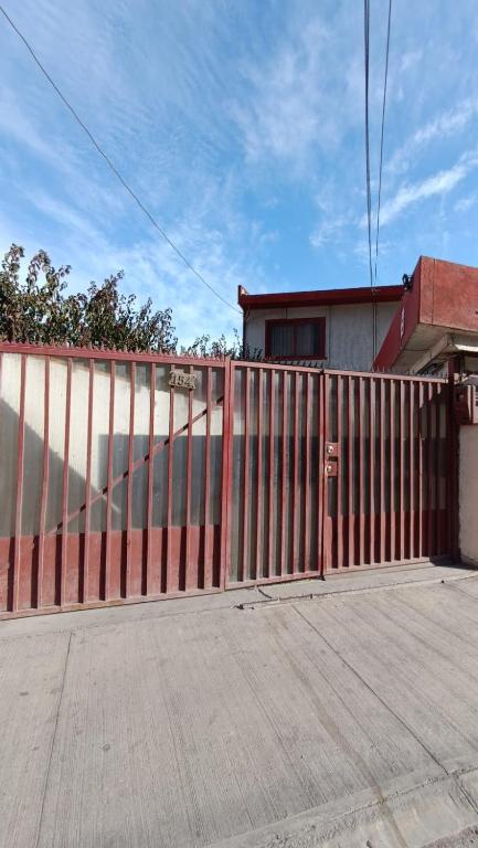 una valla roja frente a un edificio en Residencial familiar El Valle, en Copiapó