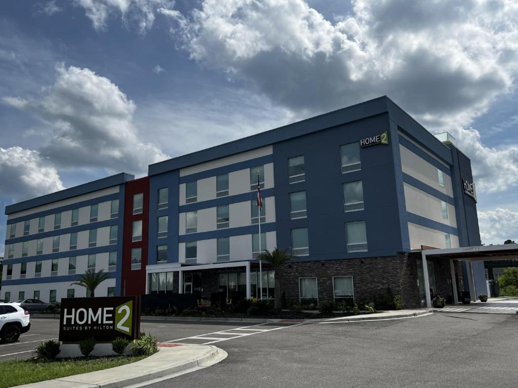a blue building with a home sign in front of it at Home2 Suites By Hilton Hinesville in Hinesville