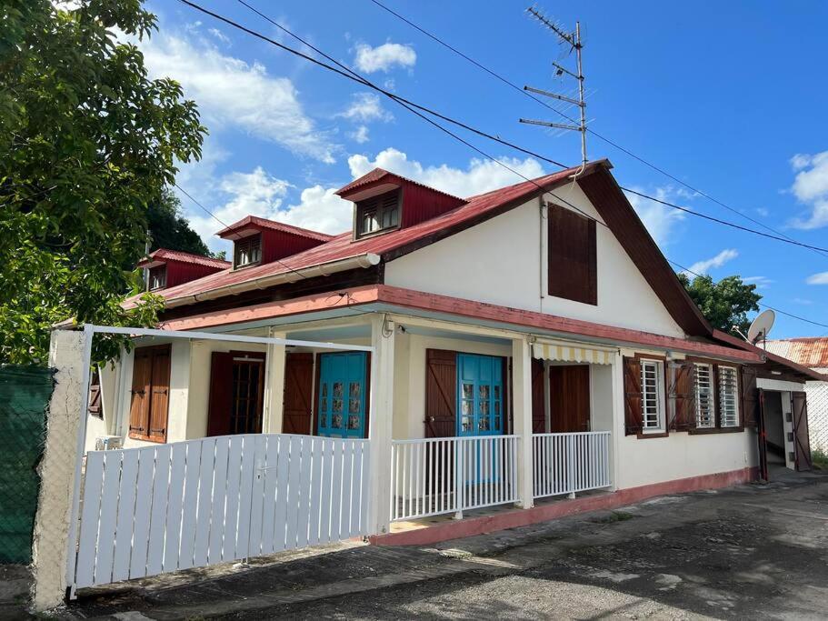 an old white house with a red roof at Kaza Ohana proche de Malendure - maison 8 à 11 personnes in Bouillante
