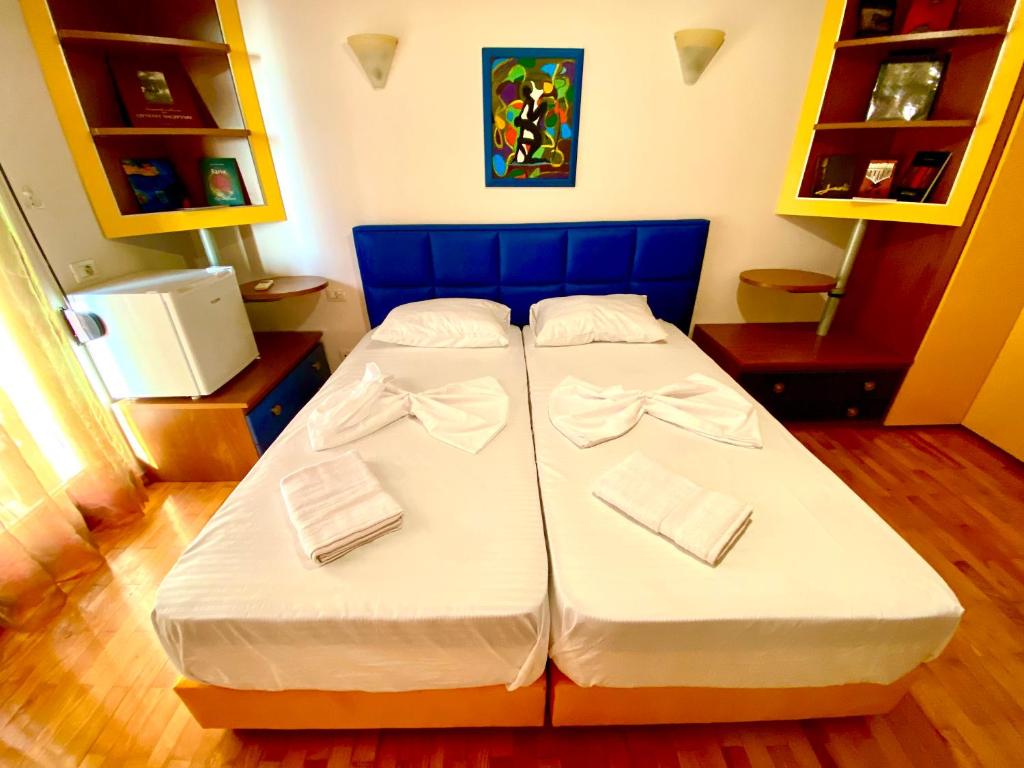 two beds in a room with a blue headboard at “Stadium” Apartment in Tirana