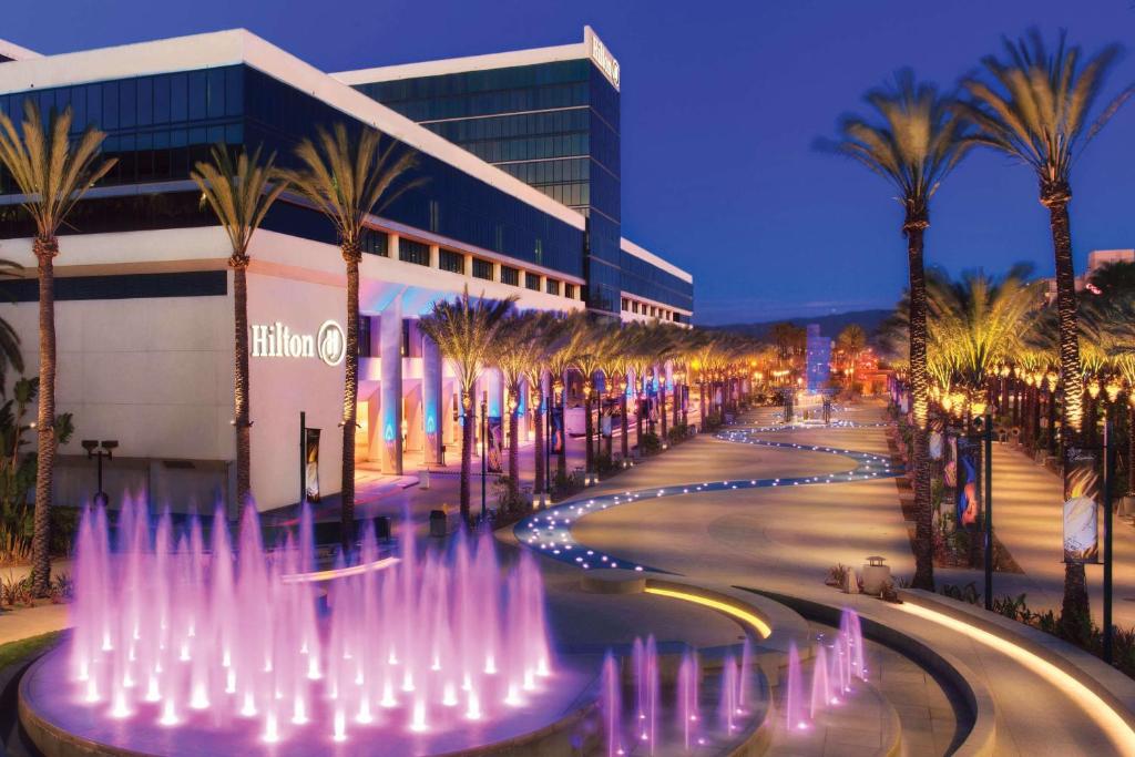 a city street with a fountain in front of a building at Hilton Anaheim in Anaheim