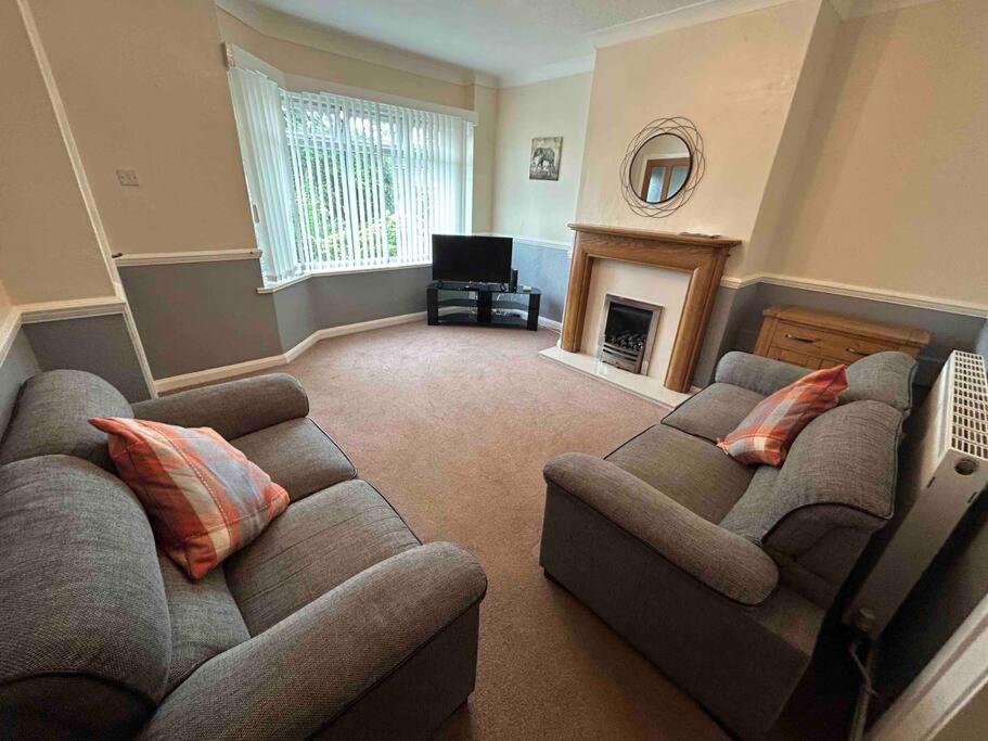 a living room with two couches and a fireplace at Lovely house & driveway parking in Kidsgrove