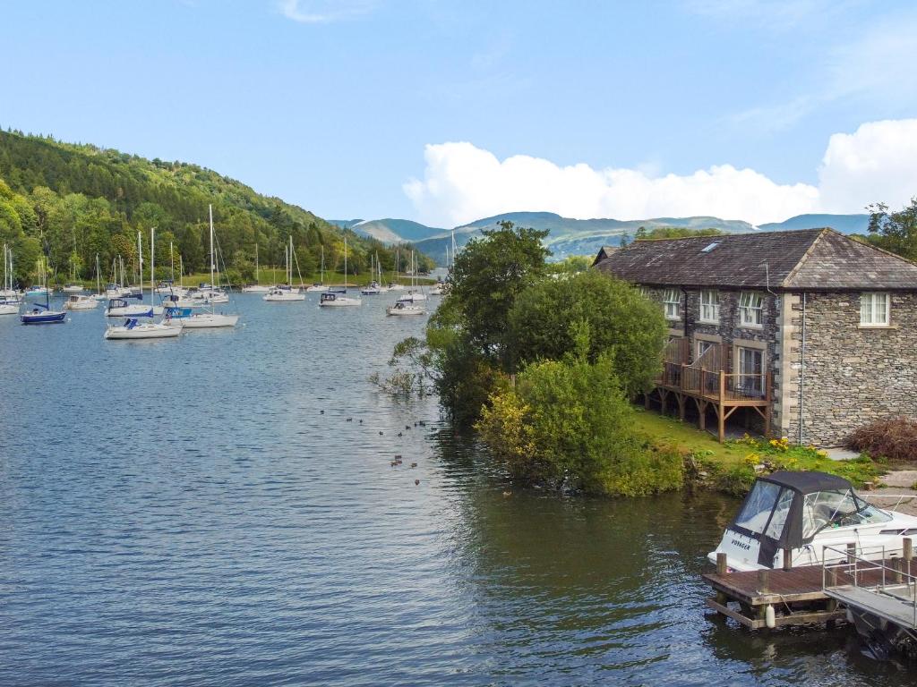 een groep boten is aangemeerd op een rivier bij Gilson in Ambleside