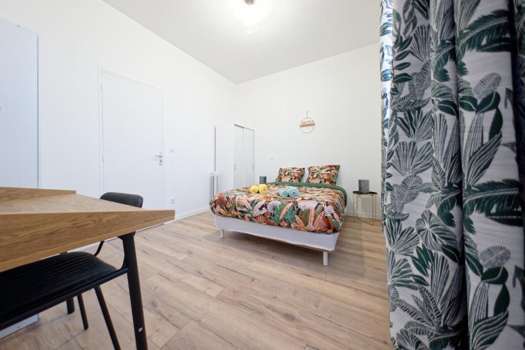 Cette chambre comprend un lit, une table, une table et une chaise. dans l'établissement L’azur - 3 personnes - Bureau & wifi, à Perpignan