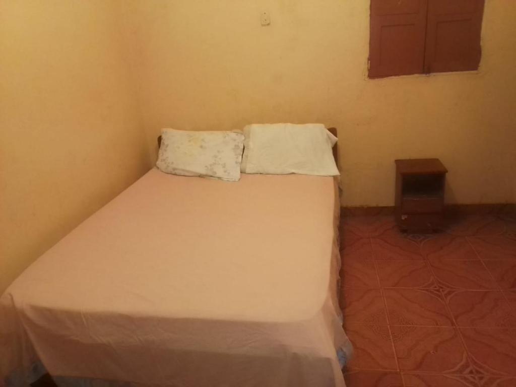 Un pequeño dormitorio con una cama blanca en una habitación en Hospedaria Zac en Luanda