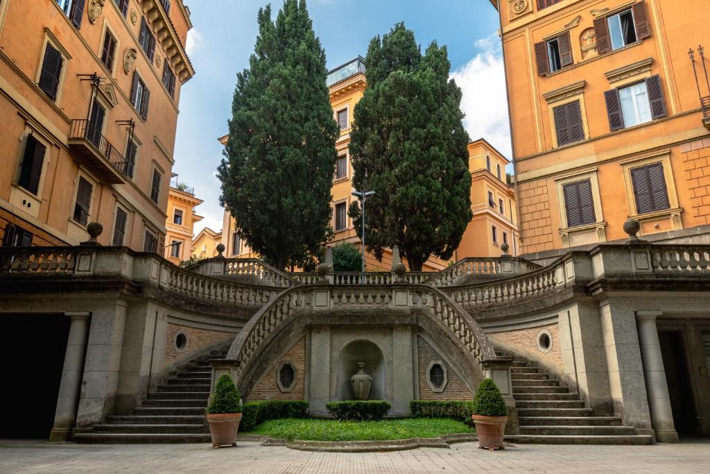 a building with stairs and trees in a courtyard at Borghese Magnolia Suite in Rome