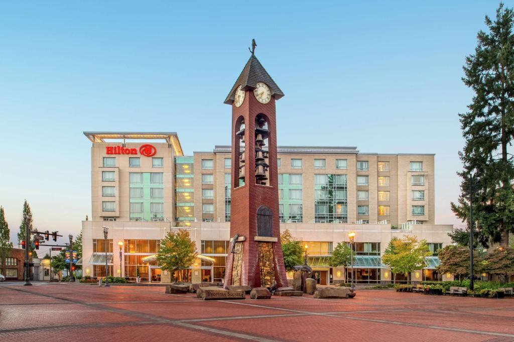 una torre de reloj frente a un edificio en Hilton Vancouver Washington, en Vancouver