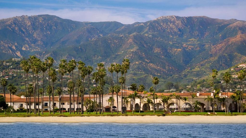 un complejo con palmeras y montañas de fondo en Hilton Santa Barbara Beachfront Resort, en Santa Bárbara