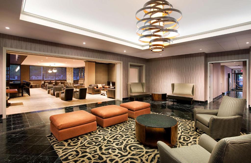 - un hall doté d'un espace d'attente avec des chaises et des tables dans l'établissement DoubleTree by Hilton Hotel & Suites Jersey City, à Jersey City