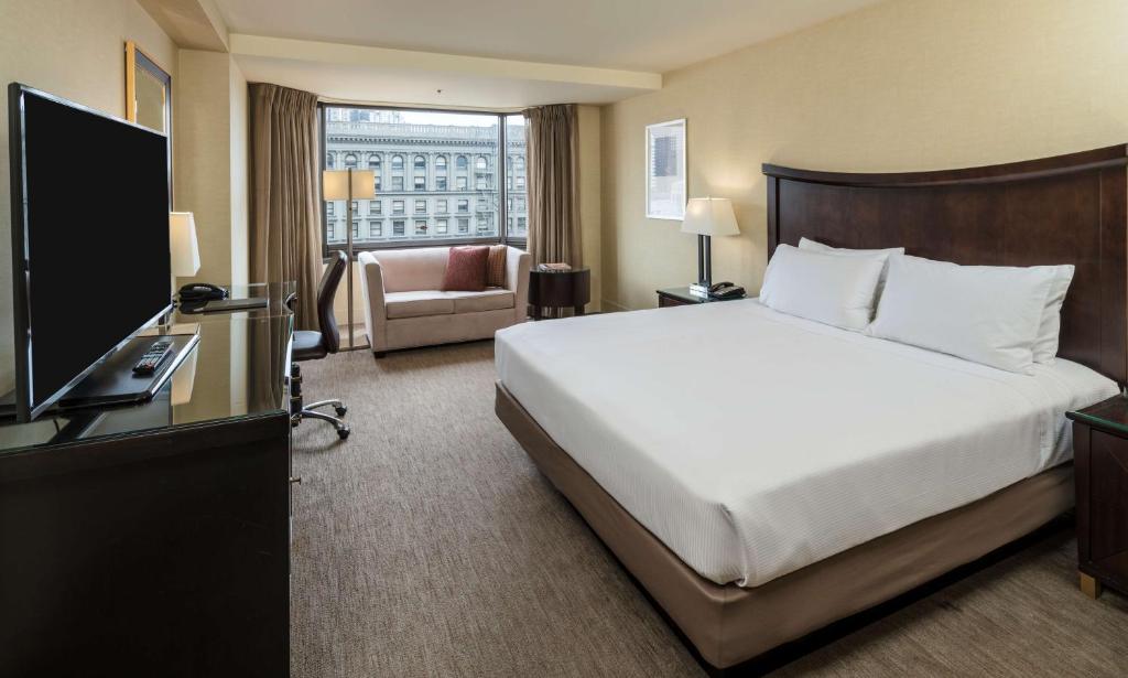 サンフランシスコにあるヒルトン パーク 55 サンフランシスコ ユニオンスクエアのベッドとテレビが備わるホテルルームです。
