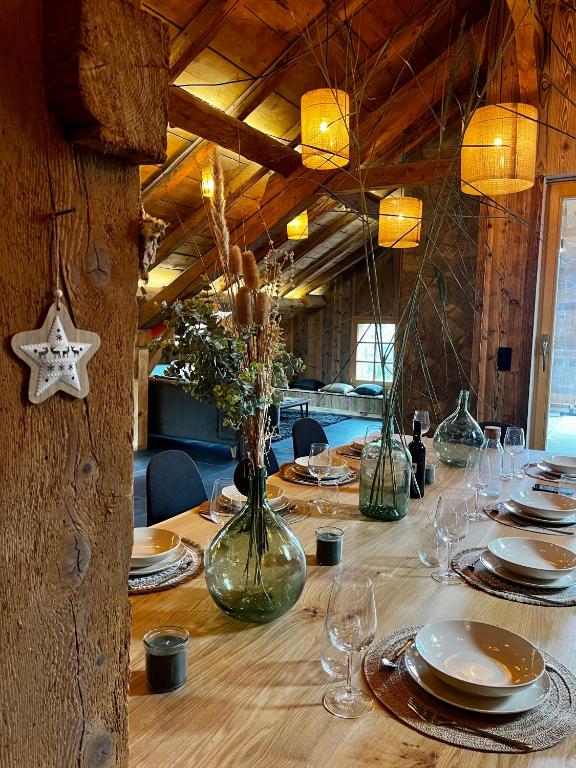 une longue table en bois avec des assiettes et des verres dessus dans l'établissement Stone Lake Luxury Lodge, à Gérardmer