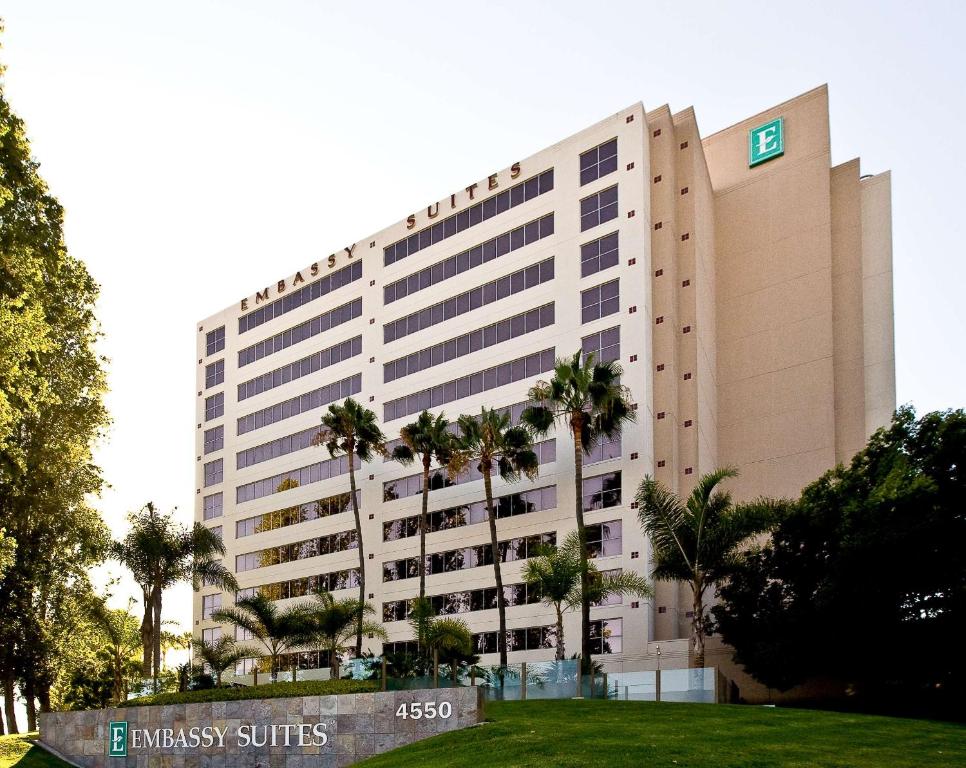 圣地亚哥Embassy Suites by Hilton San Diego La Jolla的一座前面有棕榈树的大楼
