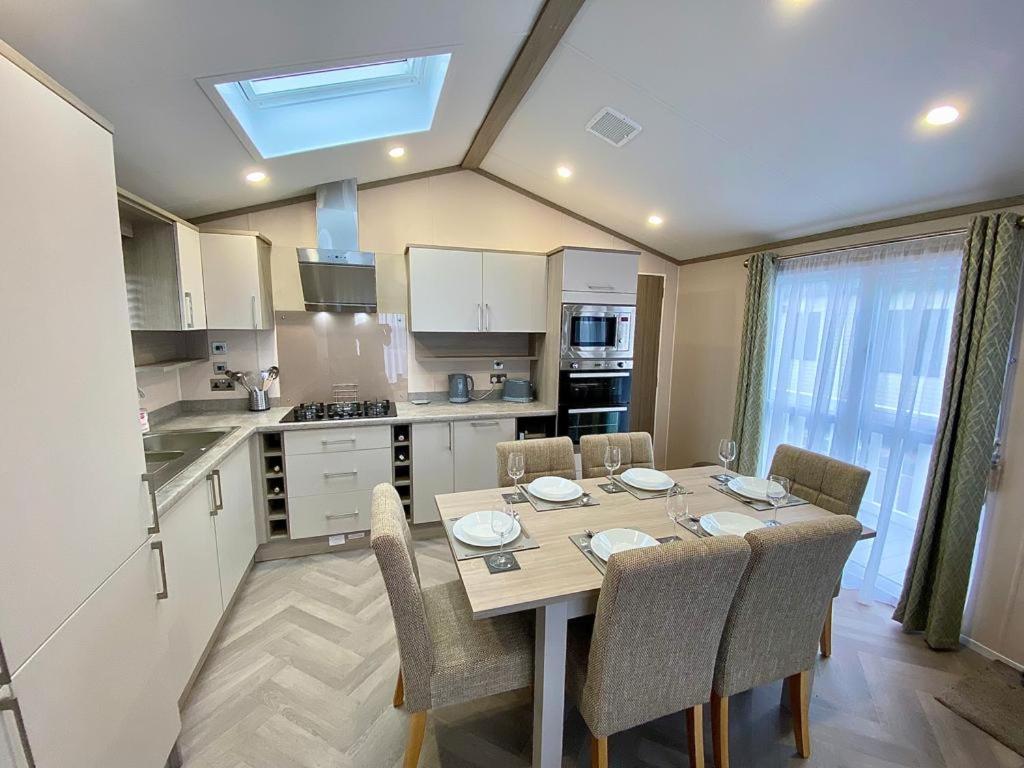 a kitchen with a table and chairs in a kitchen at The Lodge in Selsey