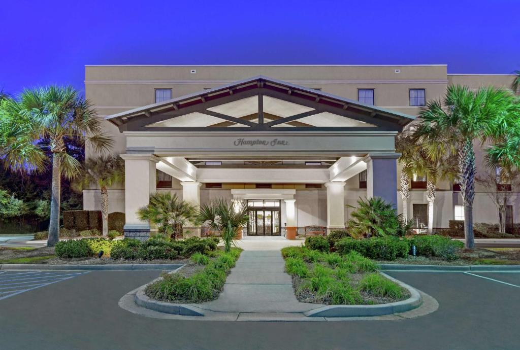 a large building with palm trees in front of it at Hampton Inn Charleston-Daniel Island in Charleston