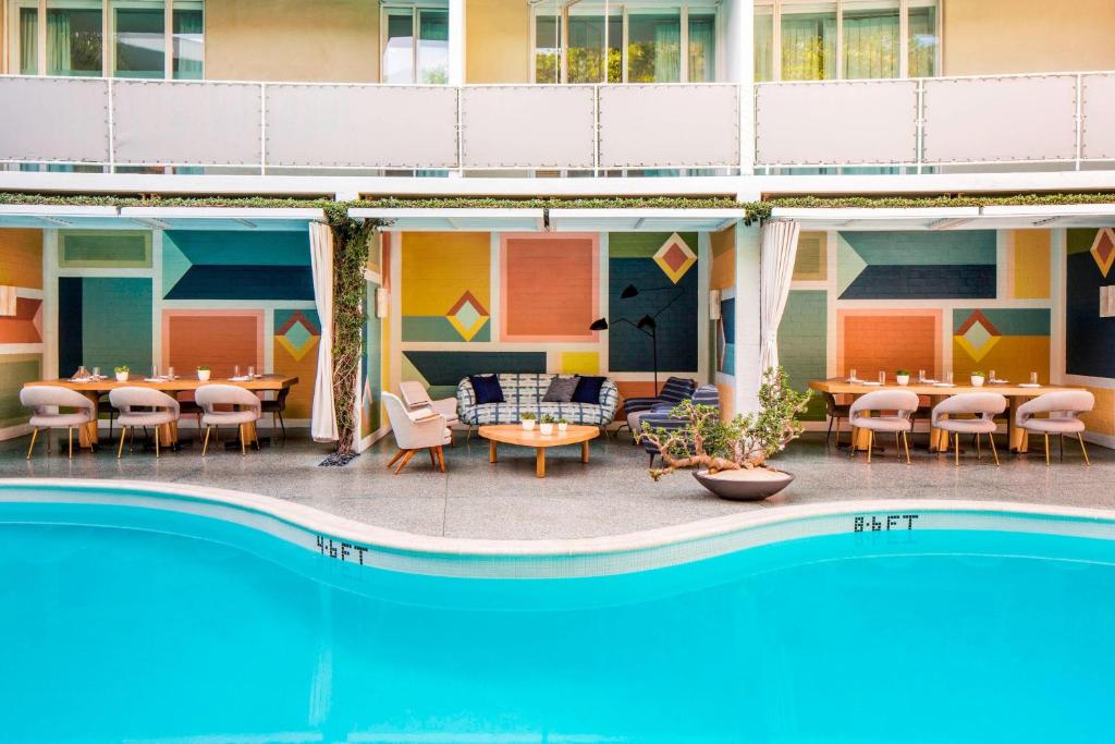 un hôtel avec un billard, des tables et des chaises à côté d'un bâtiment dans l'établissement Avalon Hotel Beverly Hills, a Member of Design Hotels, à Los Angeles