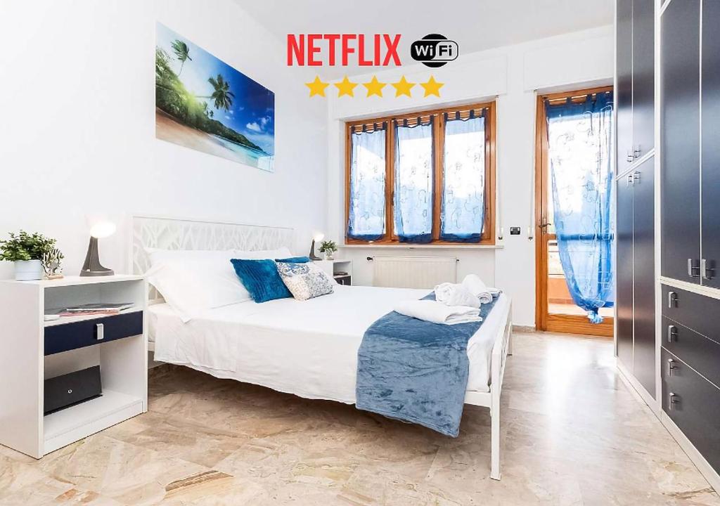 ライグエーリアにあるVista Mare & 300mt da Spiaggia con FreeParking e ACの白いベッドルーム(ベッド1台、窓付)