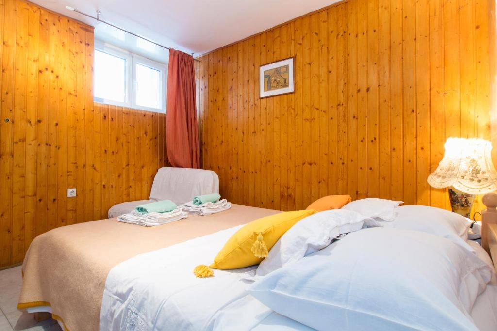 two beds in a room with wooden walls at Split Accommodation in Split