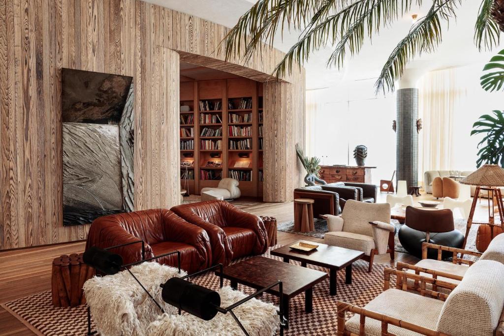 Santa Monica Proper Hotel, a Member of Design Hotels في لوس أنجلوس: غرفة معيشة مع أريكة جلدية وكراسي