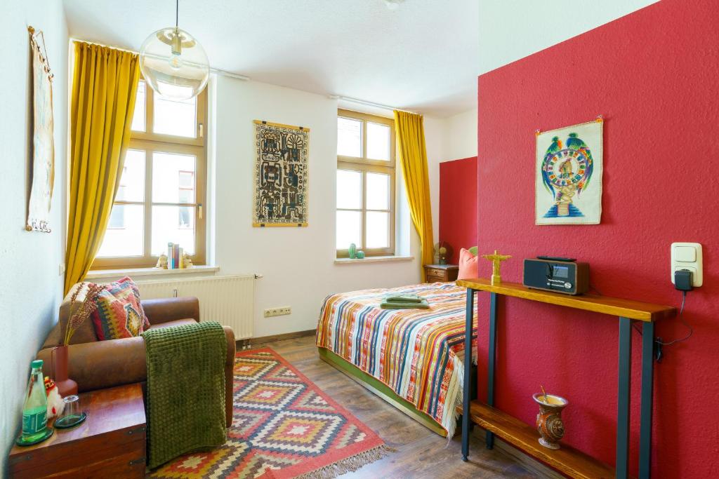 a bedroom with a bed and a red wall at Kerkermeister Pension in Auerbach