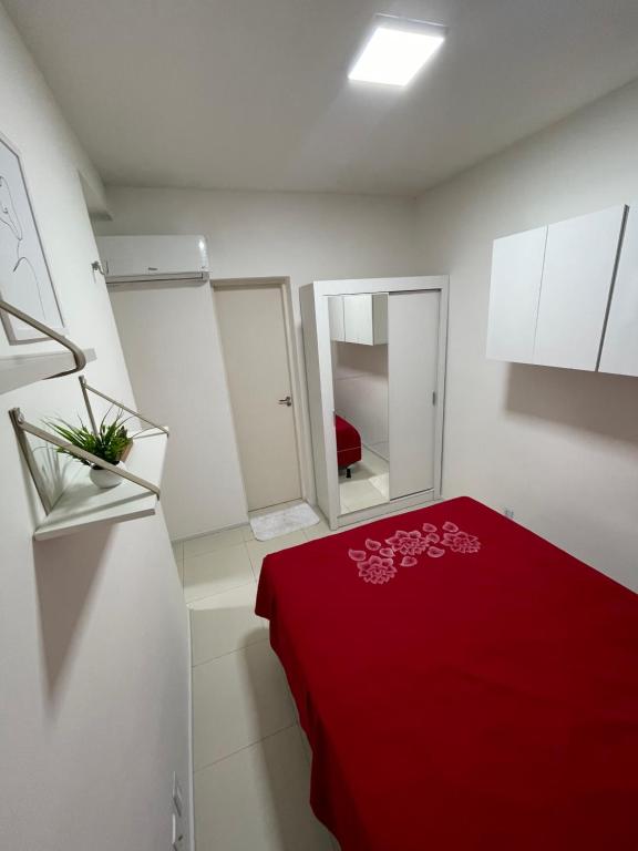 Habitación con cama roja y manta roja. en Apartamento em condomínio 24 hrs, en Juazeiro do Norte