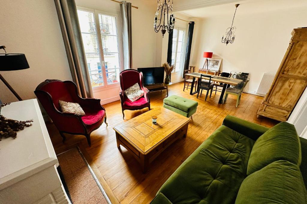 uma sala de estar com um sofá verde e cadeiras em Nice apartment with wifi near town center and Wine Museum em Bordeaux