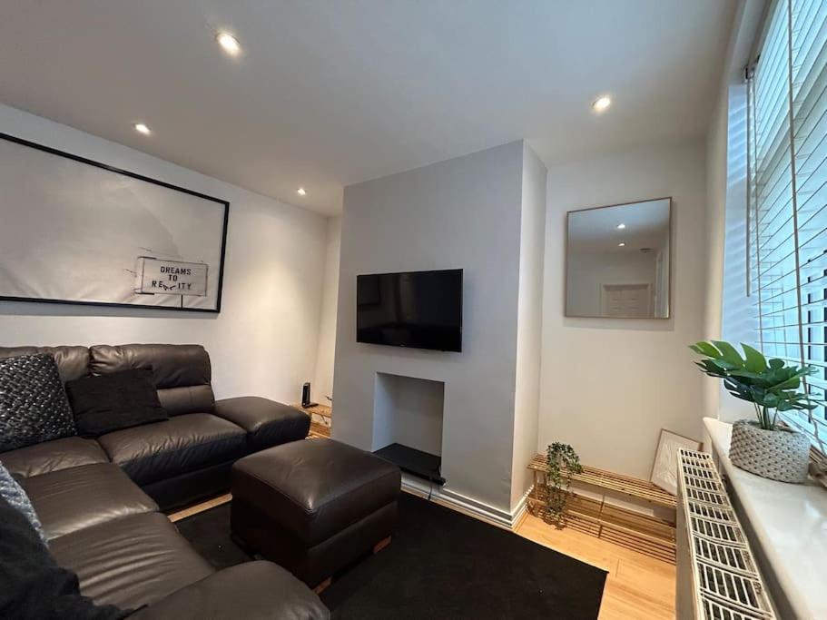 a living room with a couch and a tv at Modern & Bright 4 Bedroom Home in Stoke on Trent