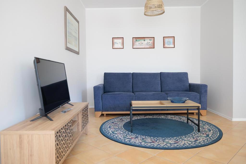 a living room with a blue couch and a table at APARTAMENTY BIAŁA MEWA - Na Wydmie 8/10 in Ustka