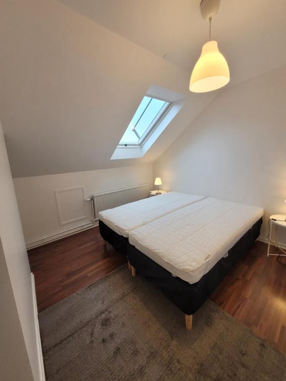 Schlafzimmer mit einem großen Bett und einem Fenster in der Unterkunft Home Inn SVE102 in Stockholm