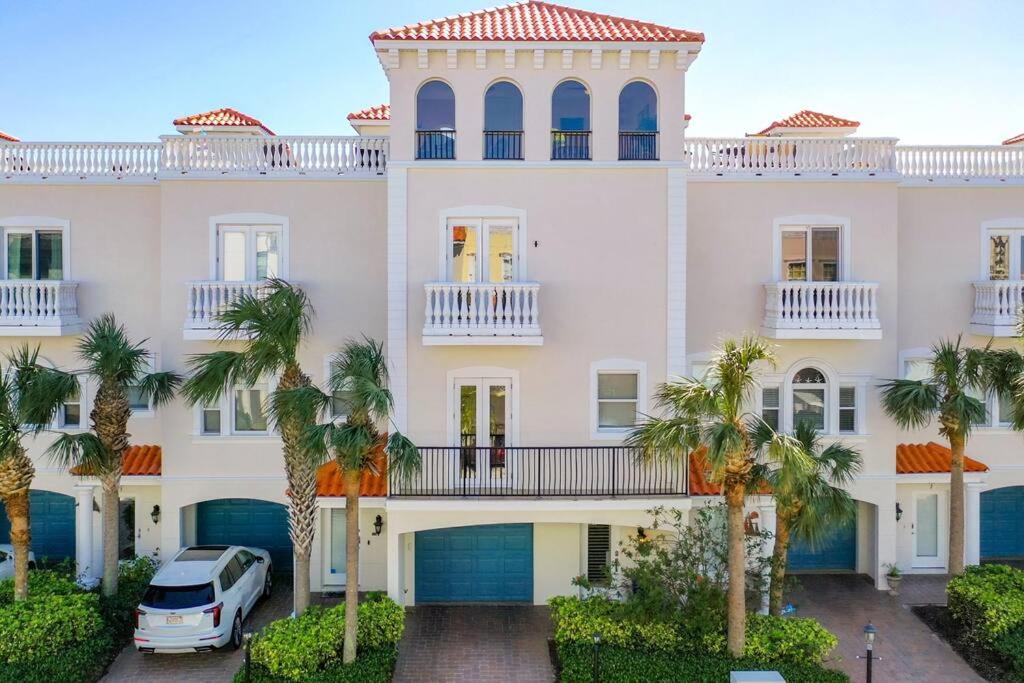 a white house with palm trees in front of it at Clearwater Penthouse 5 min Beach walk Heated Pool in Clearwater Beach