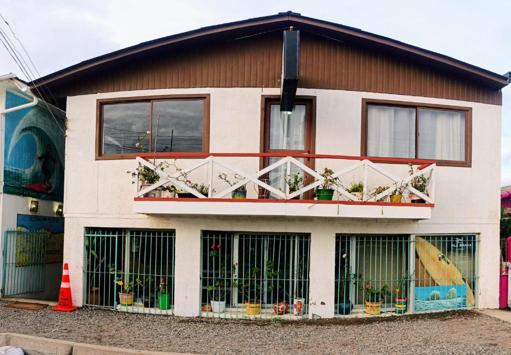 uma casa com um monte de gatos nas janelas em Hostal OlaBrava em Pichilemu