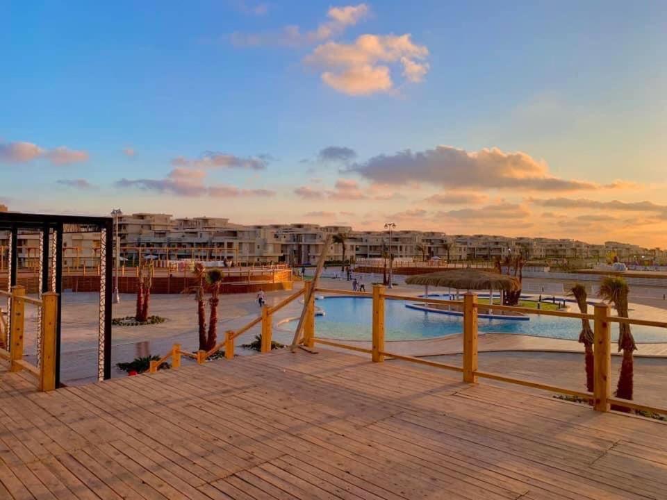 a resort with a swimming pool on a boardwalk at حجز شاليهات مارينا دلتا ومارينا لاجونز in Al Ḩammād