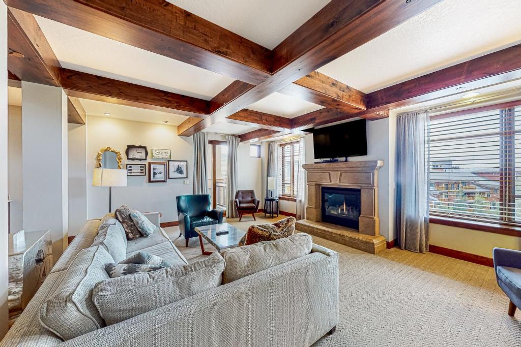 a living room with a couch and a fireplace at Canyons Sunrise in Park City