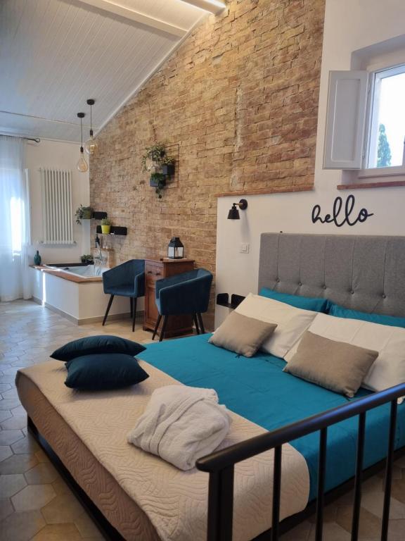 a large bed in a room with a brick wall at OgniVolta in Pienza