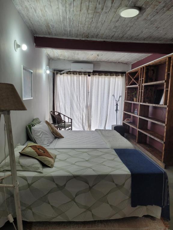 a bedroom with a large bed in front of a window at Loft Térreo no Centro in Búzios