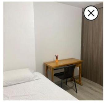 een slaapkamer met een bureau, een bed en een klok bij Sabaneta in Sabaneta
