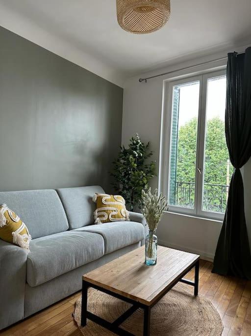 uma sala de estar com um sofá e uma mesa de centro em Joli Studio proche Paris; Stade de France em Saint-Denis