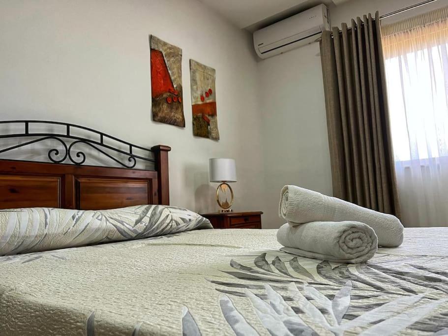 1 dormitorio con 1 cama con 2 toallas en Timeless Elegance: Vintage 3-Bedroom Apartment 