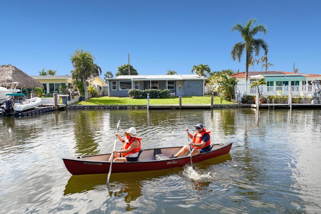 two people are rowing a boat in the water at Waterfront Fll&beaches, Bbq, Kayaks, Canoe in Dania Beach