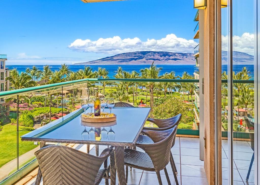 a table on a balcony with a view of the ocean at HK #539 in Lahaina