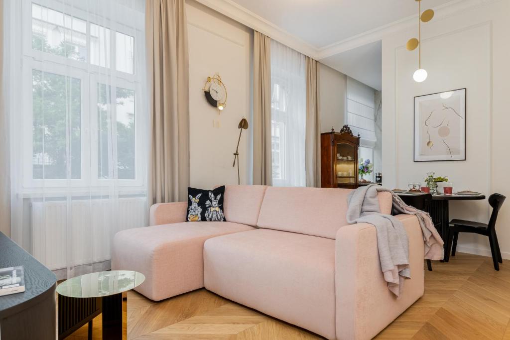 a living room with a pink couch and a table at Premium apartment in Parisian style in the heart of Old Krakow in Krakow