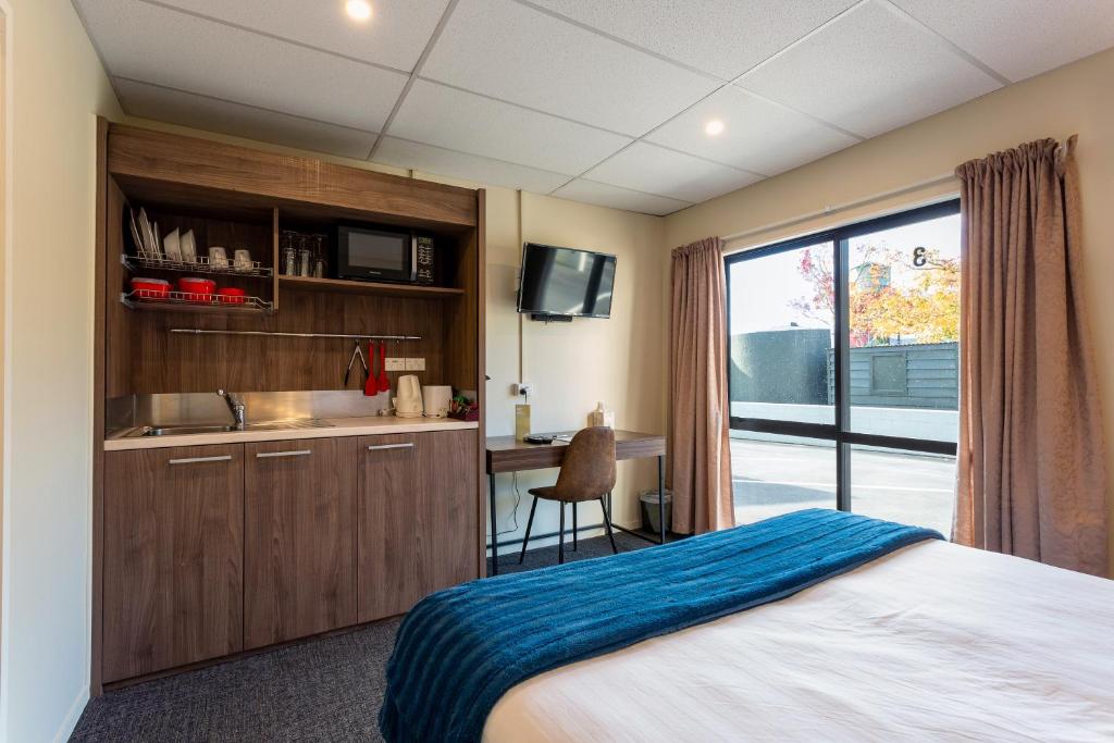 ein Schlafzimmer mit einem Bett und eine Küche mit einem Fenster in der Unterkunft Mercer Motel in Mercer