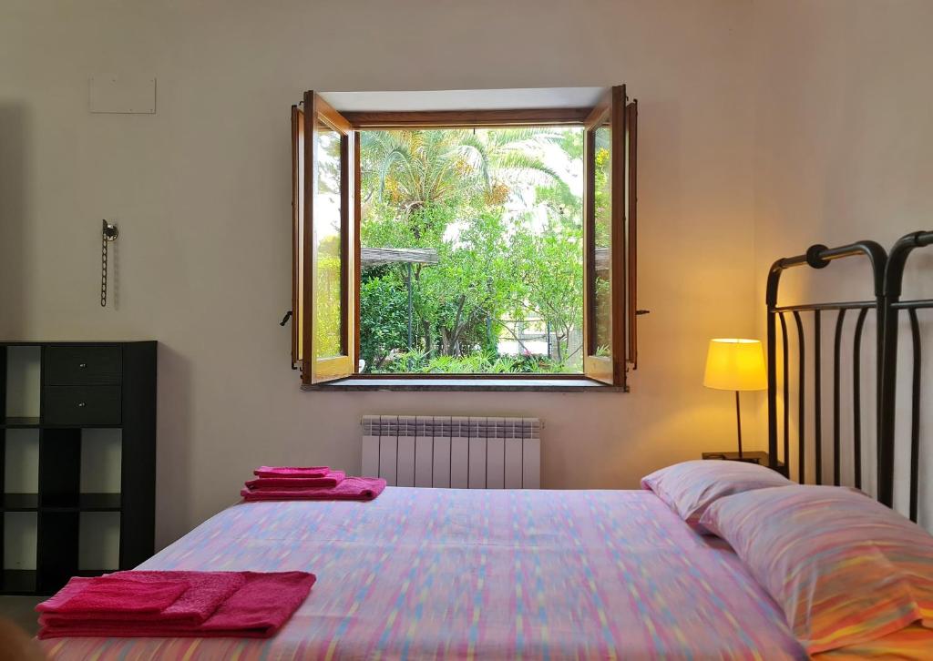1 dormitorio con 1 cama grande y ventana en Nutt House with garden near the sea, en Altavilla Milicia