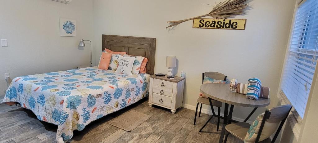 a bedroom with a bed and a table with a desk at Wave Resort, Studio A2, Beach steps away!Pool+WiFi in St Pete Beach