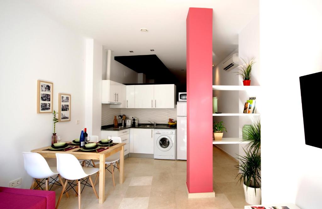 - une cuisine et une salle à manger avec une table et des chaises dans l'établissement Apartamentos PuntoApart Málaga, à Malaga