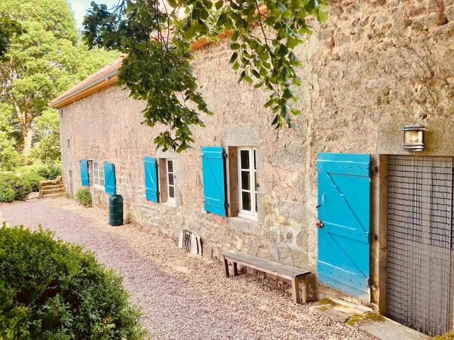 un edificio con puertas azules y un banco junto a él en Ruime woning in de Morvan, Bourgogne met seizoensgebonden zwembad, en Brassy